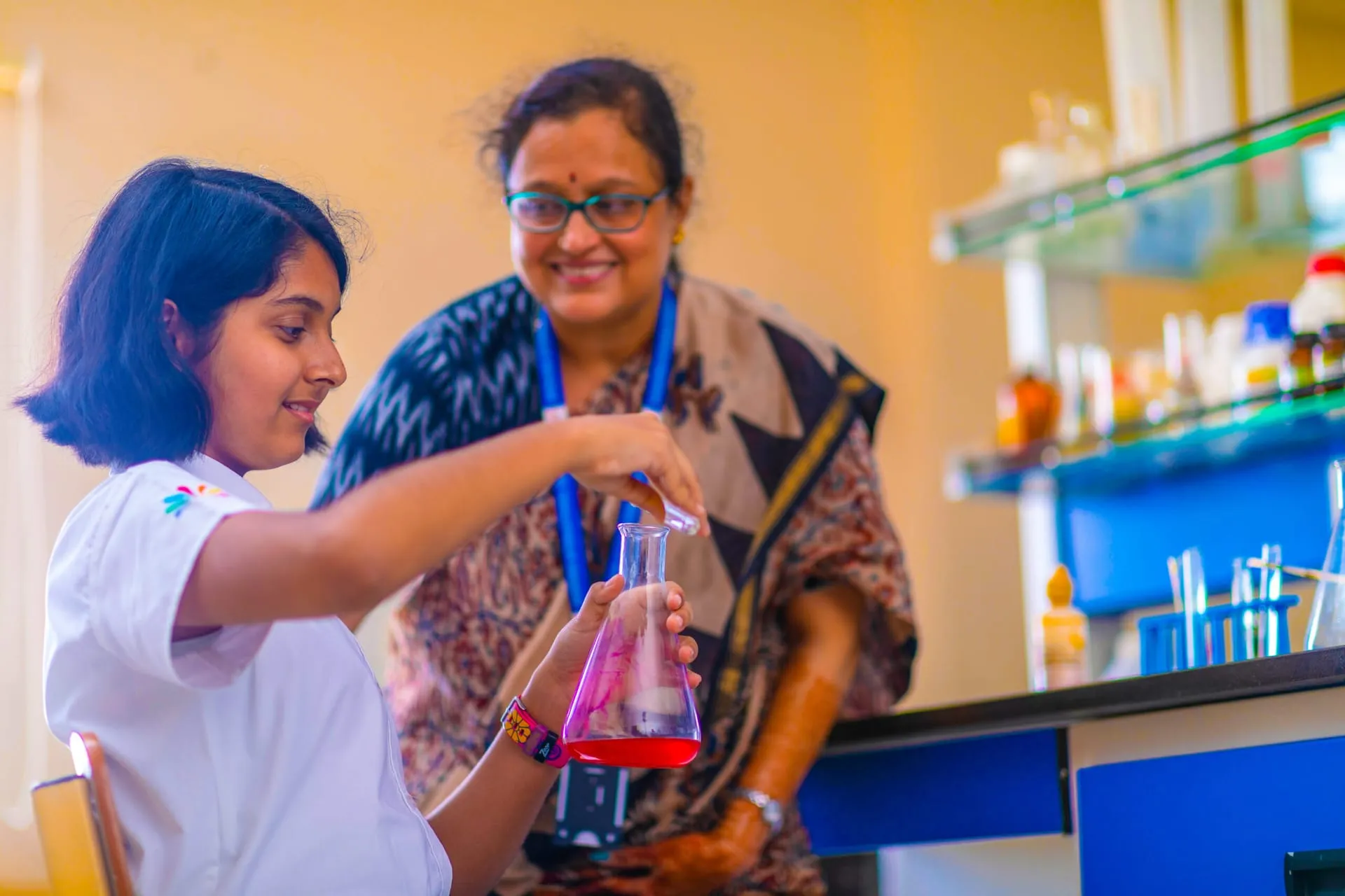 Teacher guiding a student in the chemistry lab